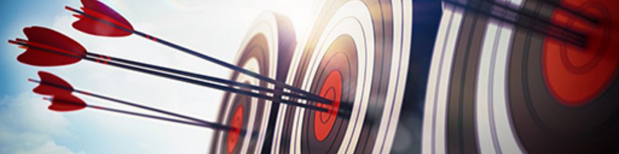 Blog banner 2000x500pxls Three target boards with darts in the middle of each one