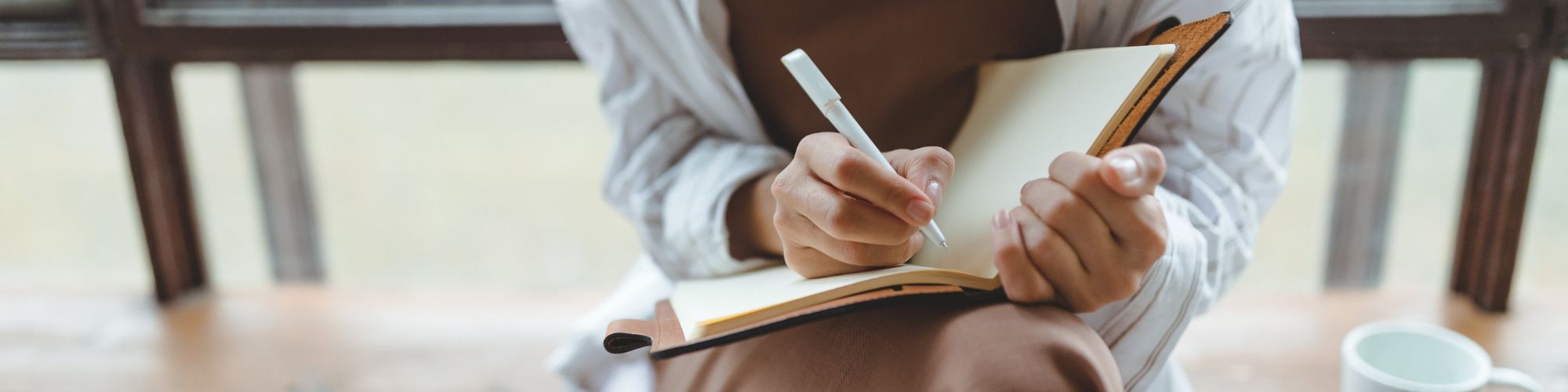 Someone writing questions in a notebook